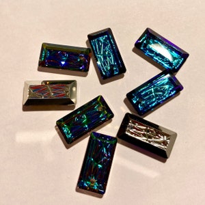 May include: Assortment of iridescent blue and silver rectangular glass rhinestones. The rhinestones have a faceted design and are perfect for crafting and jewellery making.