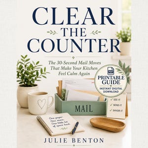 May include: A book titled Clear the Counter by Julie Benton with the subtitle The 30-Second Mail Moves That Make Your Kitchen Feel Calm Again. The cover features a green mail organiser, a white mug with a heart, a notebook, and a printable guide.