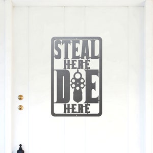 Może przedstawiać: Metalowy znak z tekstem "STEAL HERE DIE HERE" z sylwetką pistoletu w środku słowa "DIE".