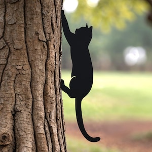 Shows a black metal cat climbing a tree.