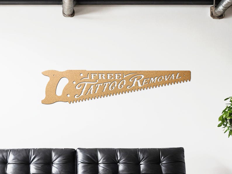 Sign shaped like a handsaw with the words Free Tattoo Removal cut out of it. Powder coated in a gold powder coat.