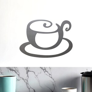 May include: A gray metal wall decor in the shape of a coffee cup and saucer.