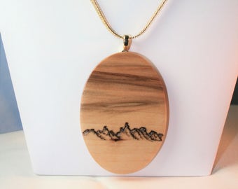 Maple - Visions in Wood Hand Carved resembling a Mountain Scene with clouds in the sky on 24" Gold tone Chain