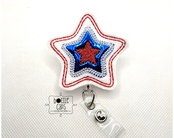 Könnte beinhalten: Ein roter, weißer und blauer sternförmiger Badgehalter mit einer durchsichtigen, einziehbaren Badge-Rolle aus Kunststoff. Der Stern hat einen roten Stern in einem blauen Stern. Der Text "bottle caps" befindet sich auf dem Badgehalter.