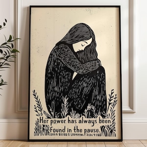 May include: Black and white illustration of a woman sitting with her head down, surrounded by plants. The text "Her power has always been found in the pause." is below the woman.