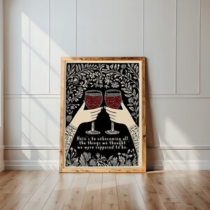 May include: A black and white illustration of two hands holding up wine glasses with red wine. The background is a floral pattern. The text reads "Here's to unbecoming all the things we thought we were supposed to be."
