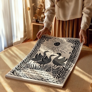 以下が含まれることがあります： 3羽の鳥が描かれた白黒のアートプリント。太陽の光線模様の下に配置され、装飾的な葉とテキスト「Her ducks are never in a row... gloriously out of sync and imperfect, but true.」が含まれています。
