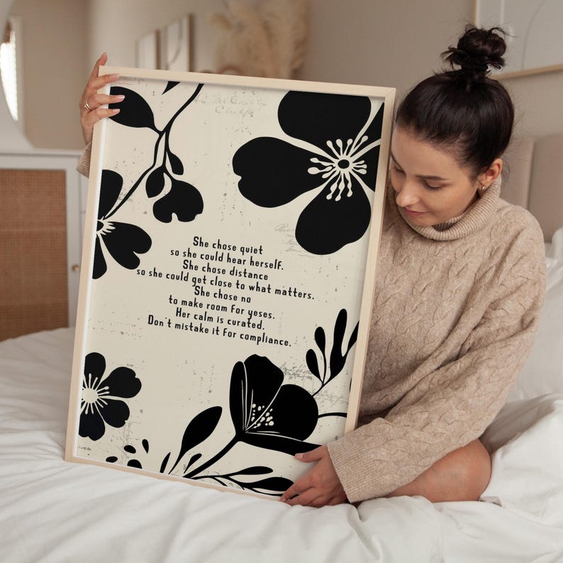 Puede incluir: Una impresi&oacute;n art&iacute;stica enmarcada con un fondo crema y dise&ntilde;os florales negros. La impresi&oacute;n incluye el texto "She chose quiet...Don't mistake it for compliance." El marco es de color madera clara.