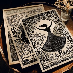 May include: Black and white art prints featuring botanical designs and a dancing figure. One print is framed in a light wood, and the others are layered on a wooden table. Text includes "Real que crowns an world" and a quote about dance.