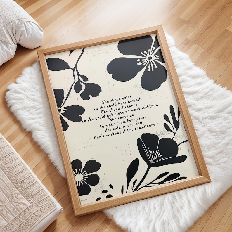 Puede incluir: Una impresi&oacute;n art&iacute;stica enmarcada con un marco de madera clara. La impresi&oacute;n presenta dise&ntilde;os florales negros y texto sobre un fondo blanquecino. El texto dice: "She chose quiet...Don't mistake it for compliance."