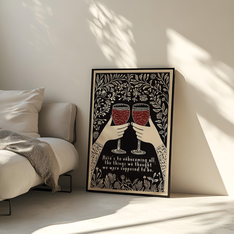 May include: Black and white illustration of two hands holding up glasses of red wine. The background is a floral pattern. The text reads "Here's to unbecoming all the things we thought we were supposed to be."
