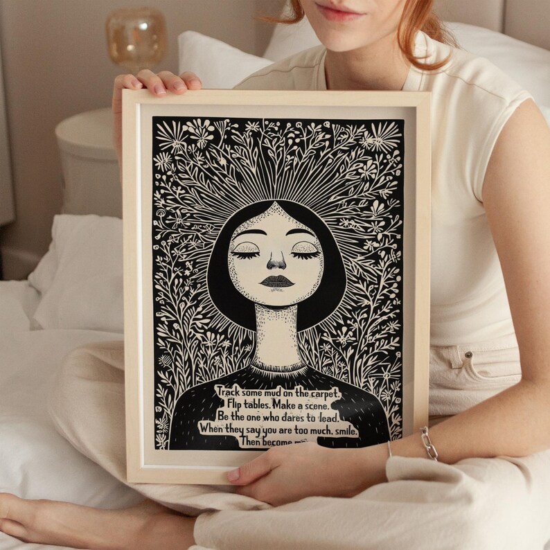 May include: Black and white illustration of a woman with her eyes closed, surrounded by flowers. The text reads: "Track some mud on the carpet. Flip tables. Make a scene. Be the one who dares to lead. When they say you are too much, smile. Then become..."