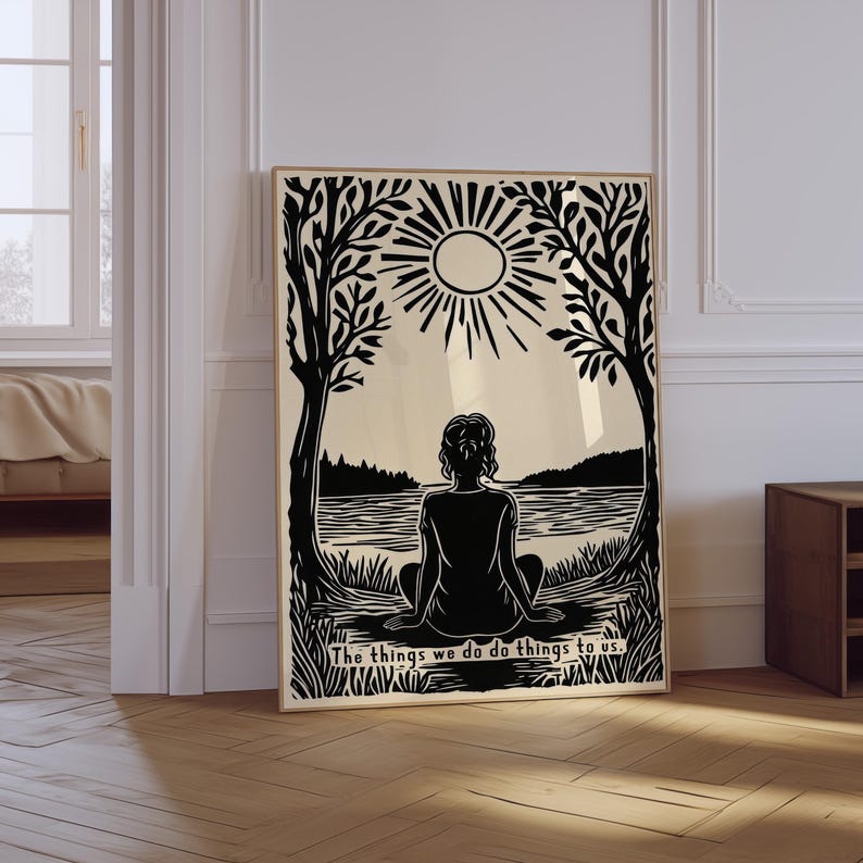 May include: Black and white art print featuring a person sitting by a lake, framed by trees and a sun. The text at the bottom reads, "The things we do do things to us."