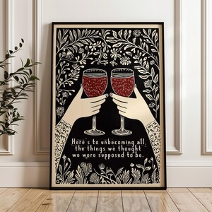 May include: Two glasses of red wine clink together in a black and white illustration with a floral border. The text reads "Here's to unbecoming all the things we thought we were supposed to be."