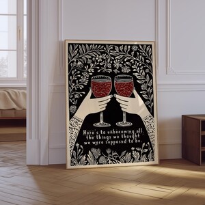 May include: Black and white illustration of two hands holding up wine glasses with red wine. The background is a black and white floral pattern. The text reads "Here's to unbecoming all the things we thought we were supposed to be."