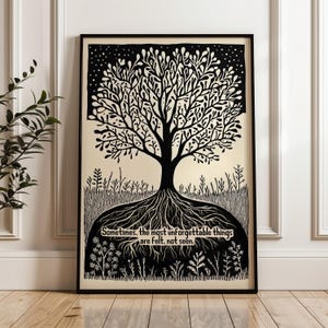 May include: Black and white framed art print featuring a tree with intricate branches and roots. The artwork includes the text: "Sometimes, the most unforgettable things are felt, not seen." The print is displayed on a light beige background.