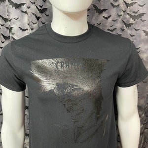 May include: Black t-shirt with a silver graphic print of a skull with the text "The Cramps" above it.