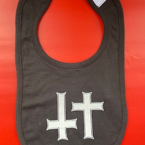 May include: A black baby bib with two white upside-down crosses.