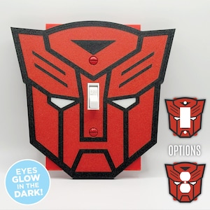 May include: Red and black light switch cover with a Transformers robot face design. The eyes glow in the dark.  Options for different robot faces are shown below.