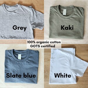 May include: Four folded t-shirts in different colors: grey, khaki, slate blue, and white. The shirts are made of 100% organic cotton and are GOTS certified.