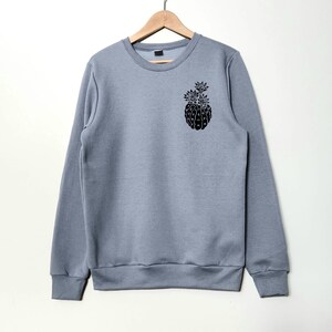 May include: A gray sweatshirt with a black graphic of a pineapple on the left chest.