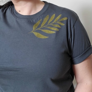 Camiseta unisex con estampado de plantas y hojas doradas, estampado a mano, ilustración minimalista iridiscente, linograbado botánico, moda ética.