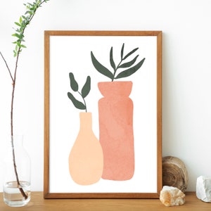 May include: A framed print of a minimalist illustration featuring two vases with green leaves. The vases are peach and pink and are set against a white background.