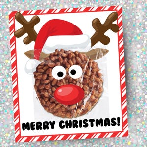 May include: A festive Christmas treat packaged in a clear wrapper, designed as a reindeer. The treat is round and brown, with white eyes, a red nose, and brown antlers. The packaging has a red and white striped border and the words "MERRY CHRISTMAS!"