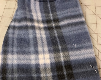May include: A blue and white plaid fleece dog vest with a black fleece lining.