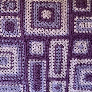 May include: A purple and light purple crochet blanket with a square pattern.