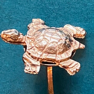 May include: Silver turtle cufflinks with a detailed design. The turtle is standing on a round base. The cufflinks are about the size of a dime.