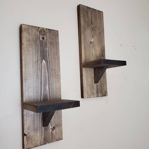 Puede incluir: Dos estantes de pared de madera r&uacute;stica con un tinte marr&oacute;n oscuro. Cada estante tiene una peque&ntilde;a repisa para exhibir art&iacute;culos.
