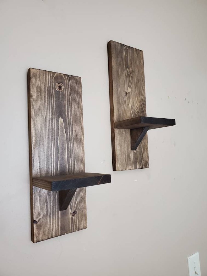 Puede incluir: Dos estantes de pared de madera r&uacute;stica con un tinte marr&oacute;n oscuro. Cada estante tiene una peque&ntilde;a repisa para exhibir art&iacute;culos.