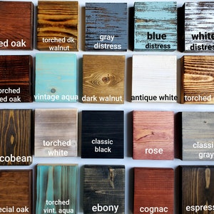 May include: A collection of 16 wood stain samples, showcasing various colors and finishes. The samples include red oak, torched walnut, gray distress, blue distress, white distress, torched red oak, vintage aqua, dark walnut, antique white, torched raw, jacobean, torched white, classic black, rose, classic gray, special oak, torched vint. aqua, ebony, cognac, and espresso.