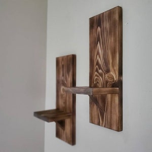 Puede incluir: Dos estantes de pared de madera r&uacute;stica con un tinte marr&oacute;n oscuro. Los estantes est&aacute;n hechos de madera recuperada y tienen un aspecto &uacute;nico y natural.