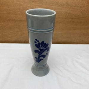 May include: A gray ceramic beer stein with a blue floral design.