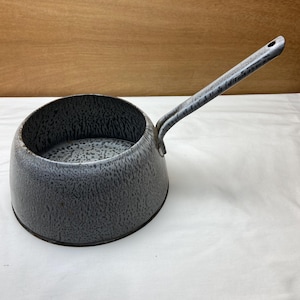 May include: A gray speckled enamel saucepan with a long handle. The handle is attached to the side of the pan.