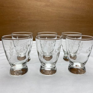 May include: Set of six clear glass drinking glasses with a white etched leaf design. The glasses have a rounded base and a wide mouth.