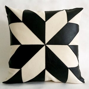 Peut inclure: Un coussin de décoration avec un motif géométrique noir et blanc. Le coussin est fait d'un tissu doux et texturé et a une forme carrée.
