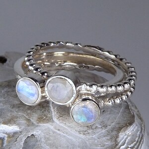 May include: Three silver rings with moonstone gemstones. The rings are stacked on top of each other and have a beaded design.