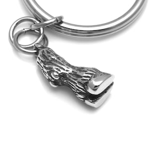 May include: Silver key chain with a detailed tree trunk charm. The charm is attached to a silver ring.