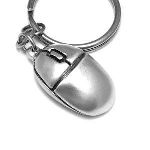 Può includere: Un portachiavi a forma di mouse per computer argentato con un anello per chiavi.