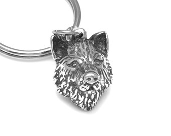 May include: A silver wolf head keychain with a detailed design. The wolf's head is facing forward with its mouth closed. The keychain is attached to a silver ring.