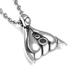 Puede incluir: Un collar con un colgante de plata con un dise&ntilde;o abstracto &uacute;nico. El colgante tiene una forma redondeada con dos peque&ntilde;os c&iacute;rculos en el centro.
