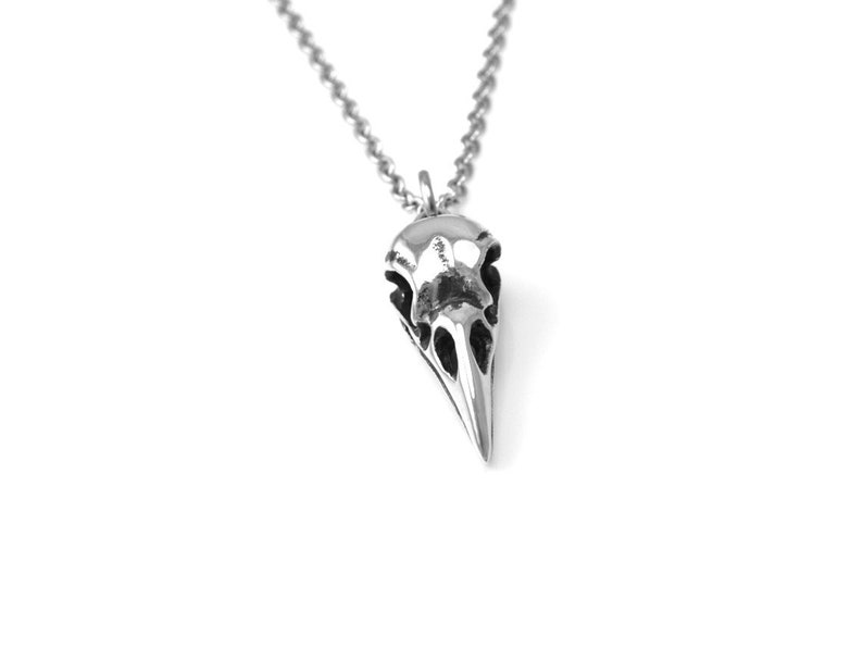 May include: A silver pendant necklace featuring a detailed bird skull design.