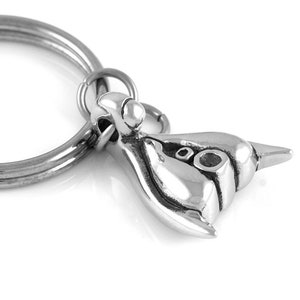 May include: Silver keychain featuring a detailed, three-dimensional sculpture of a seahorse. The keychain is attached to a silver ring.