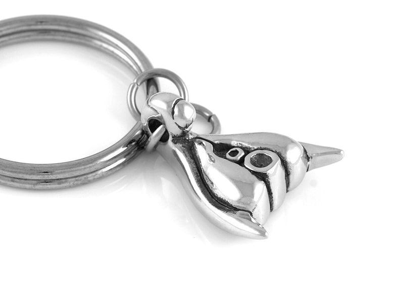 May include: Silver keychain featuring a detailed, three-dimensional sculpture of a seahorse. The keychain is attached to a silver ring.