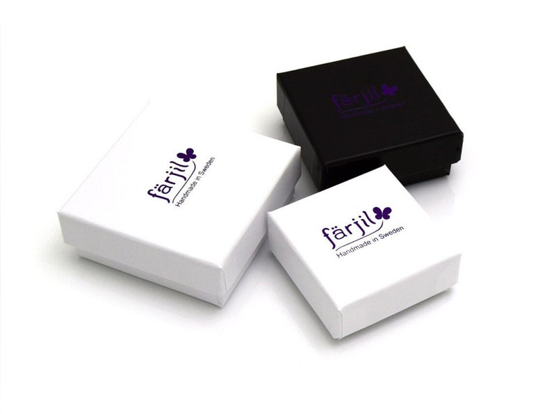 May include: Three small square boxes with the logo "f&auml;rjil Handmade in Sweden" printed on the top. The boxes are white with a black box in the background.