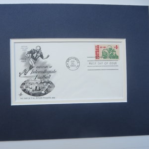 May include: A framed commemorative envelope marking 100 Years of Intercollegiate Football. The envelope includes a football player illustration, a stamp with football players, and the text "First Day of Issue". The date on the envelope is September 29, 1969.