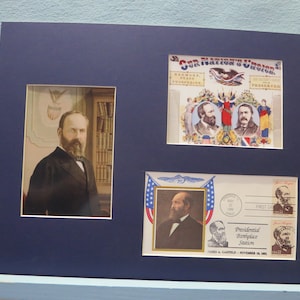 May include: A framed print of a historical image featuring James A. Garfield, the 20th President of the United States. The print includes a portrait of Garfield, a stamp with his image, and a commemorative envelope with the text "Presidential Workplace Station, James A. Garfield, November 19, 1881".